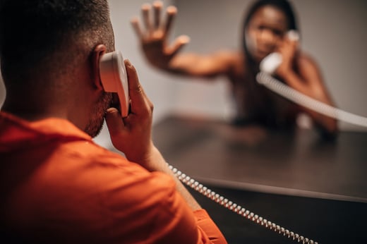 Male prisoner talking with his sad wife in prison visit room stock photo